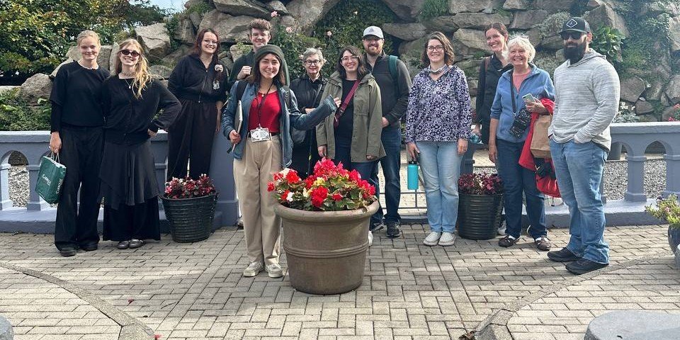 large group in front of stone building 