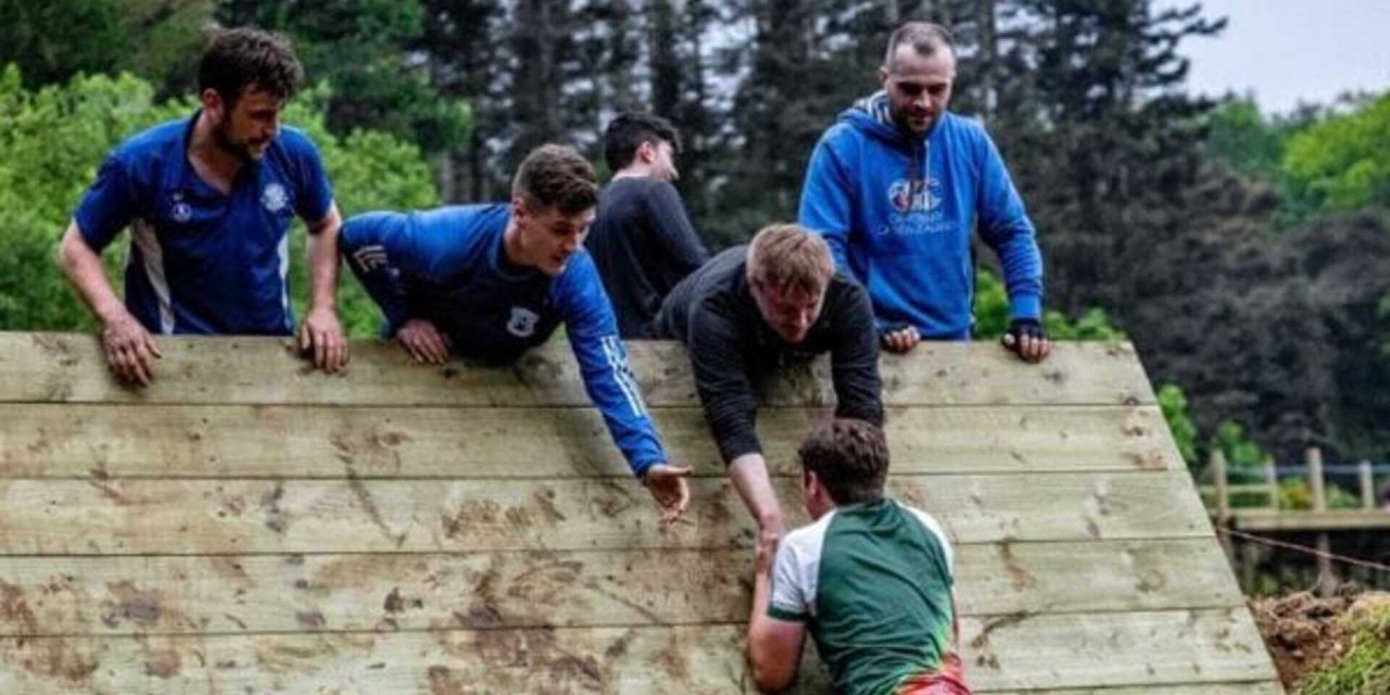 blue-jumper-activity-climbing-group-helpig-eachother