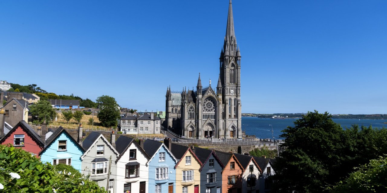 Cobh, County cork with an old church several colourful houses and the sea in the background 